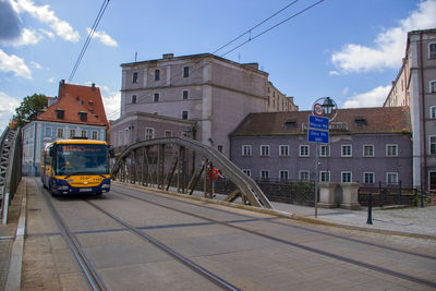 Cars on city street against sky