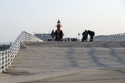 Man standing by built structure against clear sky