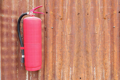 Close-up of fire extinguisher on metal wall