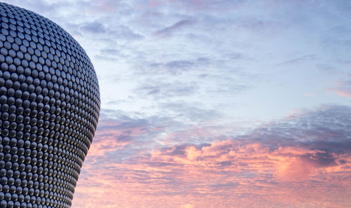 Low angle view of modern building against sky during sunset