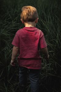 Rear view of boy standing on field