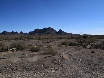 Scenic view of desert against clear blue sky