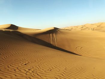 Sand dunes in desert against clear sky