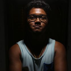 Close-up portrait of young man over black background