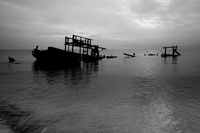 Silhouette ship in sea against sky