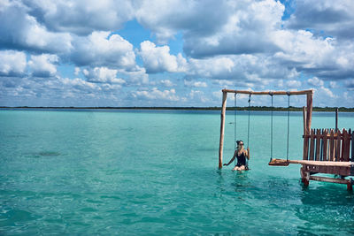 Woman in swimming pool against sea