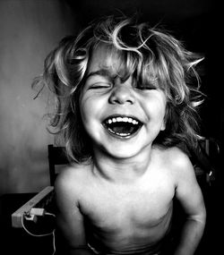 Cheerful shirtless boy sitting at home