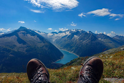 Low section of person on mountain against sky