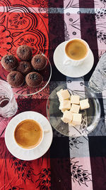 High angle view of coffee cups with sweet food on table