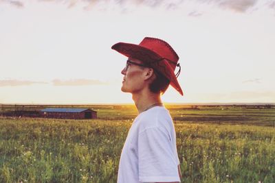 Man standing on field against sky during sunset