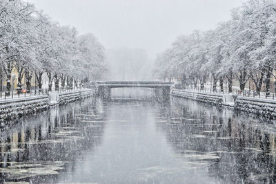 Bridge over river during snowfall 