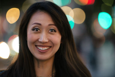 Close-up portrait of happy young woman outdoors at night