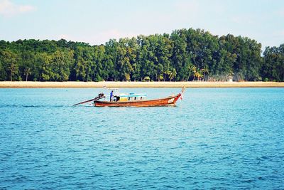 Boat sailing in river against sky