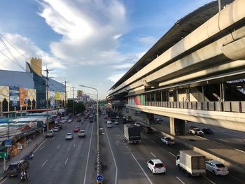 Cars on road in city against sky