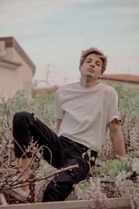 Full length of young man sitting on field