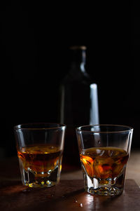 Close-up of beer glass on table against black background