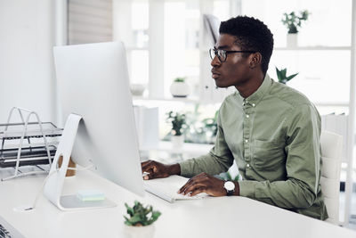 Man using mobile phone while sitting on table