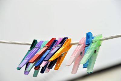 Close-up of multi colored clothespin over white sky