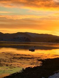 Scenic view of lake against orange sky