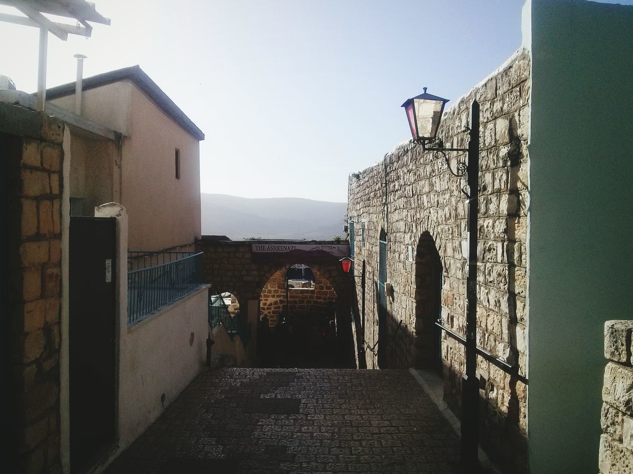 architecture, built structure, building exterior, the way forward, clear sky, narrow, diminishing perspective, sky, arch, house, day, sunlight, residential structure, building, walkway, residential building, footpath, outdoors, empty, leading