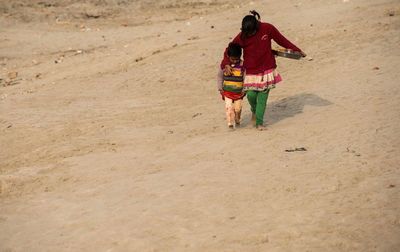 Rear view of couple walking on beach