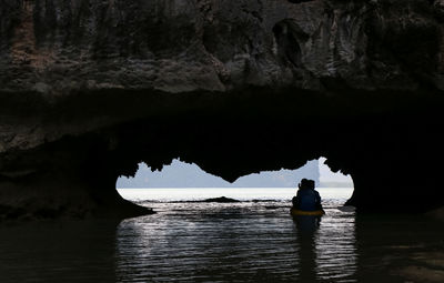 Silhouette rock in sea against sky