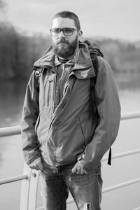 Portrait of young man standing by lake