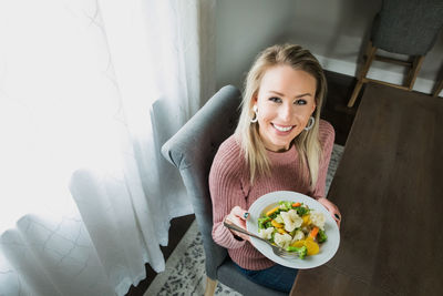 Portrait of a smiling young woman sitting at home