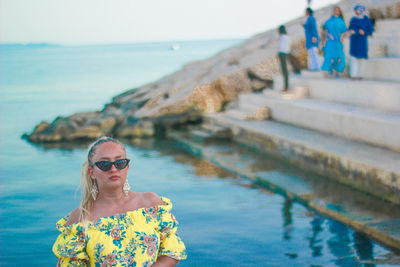 Portrait of woman standing against sea