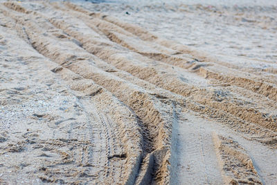 High angle view of tire tracks on sand