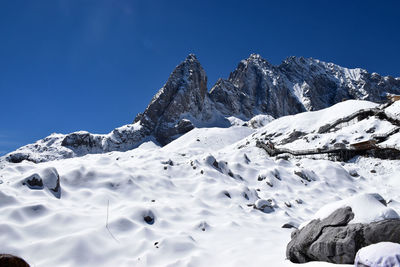 Scenic view of snowcapped mountains against clear blue sky