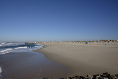 View of beach against clear blue sky