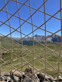 Low angle view of mountain from inside a wood cage