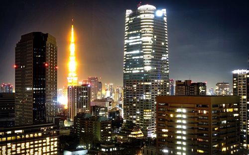 Illuminated buildings against sky at night