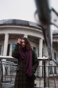 Low angle portrait of confident young woman standing in the city