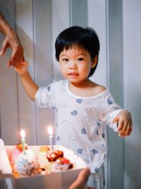 Portrait of cute girl blowing birthday cake