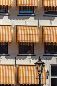 Leiden, netherlands, lamppost with orange overhang sunshade and modern building facade 