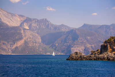 Scenic view of sea and mountains against sky