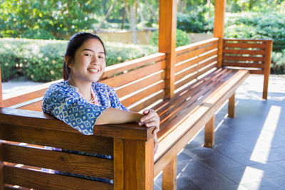 Portrait of smiling girl sitting on bench