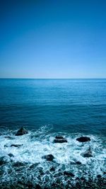 Scenic view of sea against clear blue sky