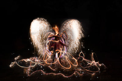 Illuminated sparkler at night