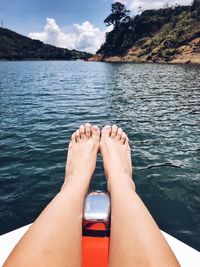Low section of man on sea against sky