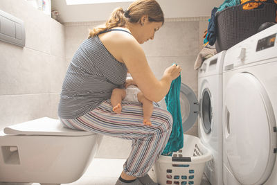 Side view of woman washing hands in bathroom