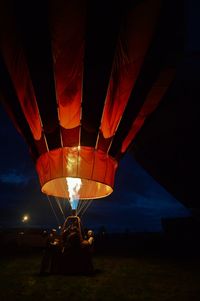 Hot air balloon on field against sky at night