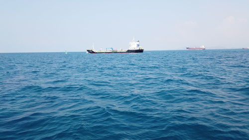 Boat sailing in sea against clear sky