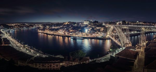 Aerial view of arch bridge over river against sky at night