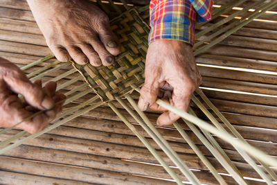 Low section of person working on wicker