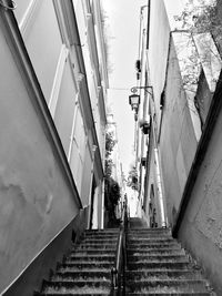 Low angle view of steps amidst buildings against sky 