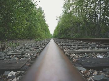 Railroad track amidst trees against clear sky