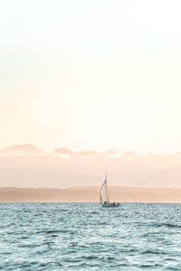 Sailboat in sea against clear sky